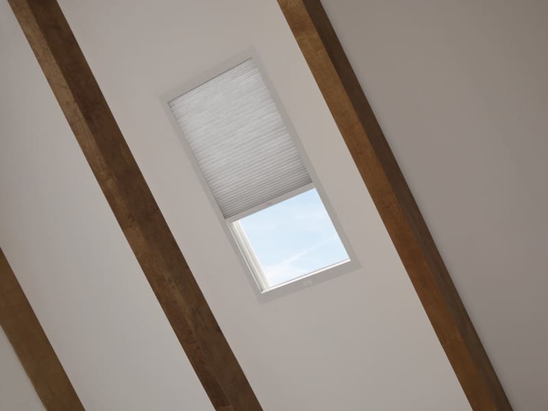 A window in an attic with wooden beams.